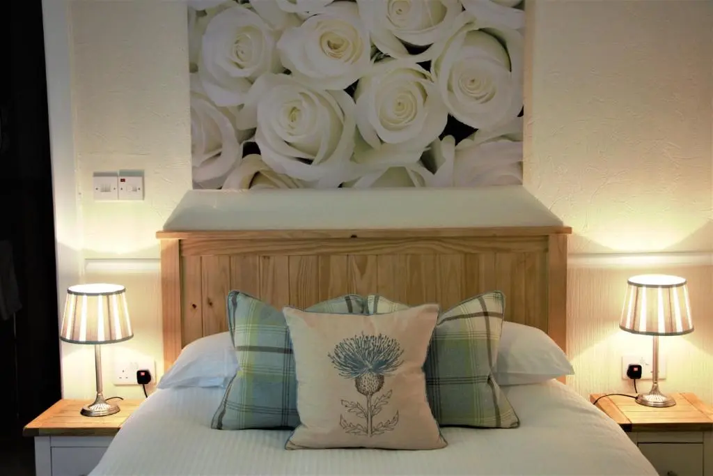 a bedroom with a flower mural above a bed at Glenmoriston Arms Hotel in Invermoriston