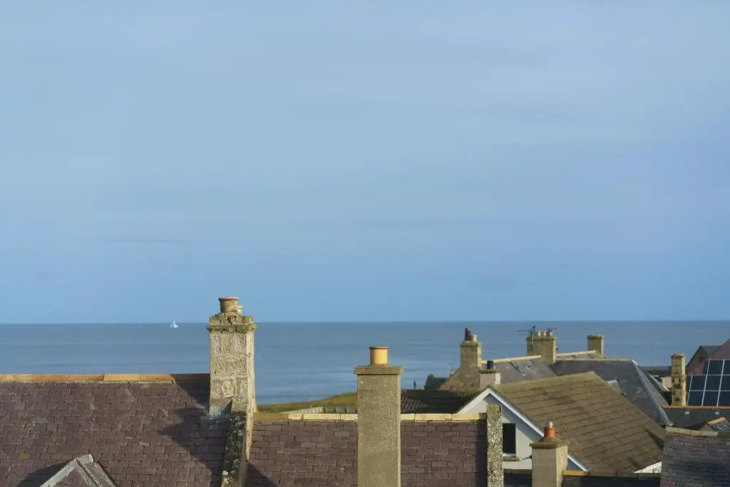 a group of roofs with the ocean in the background at Lossiemouth Haven in Lossiemouth