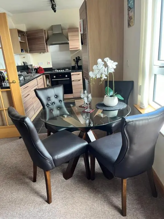 a dining room with a glass table and chairs at Lossiemouth Haven in Lossiemouth