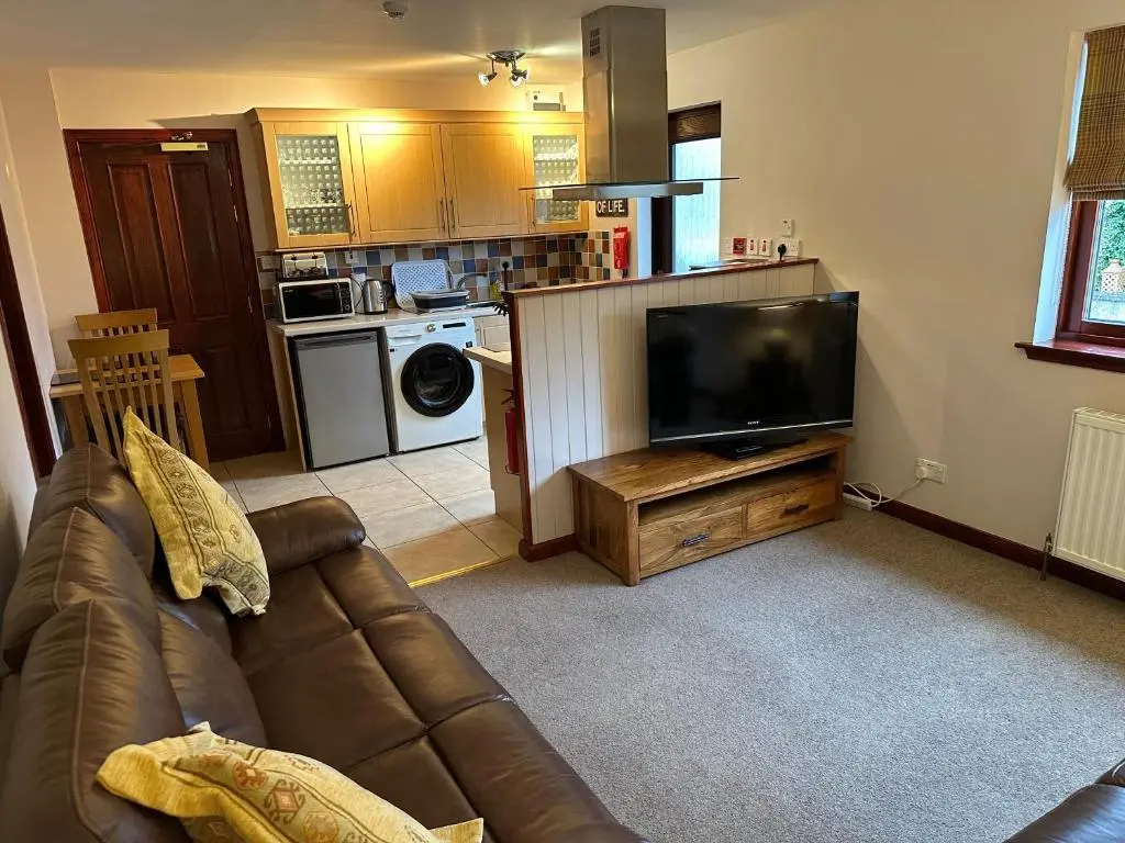 a living room with a couch and a flat screen tv at Dunhallin House in Inverness