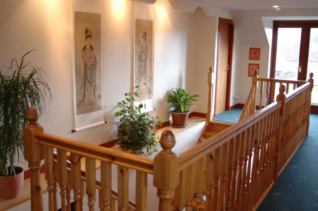a hallway with a staircase with potted plants at Dunhallin House in Inverness