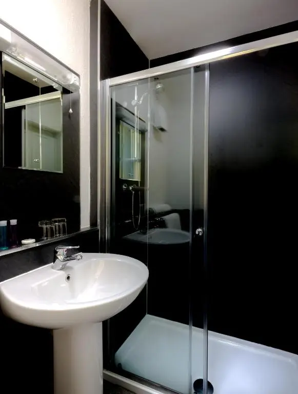a bathroom with a sink and a glass shower at Inch Hotel in Fort Augustus