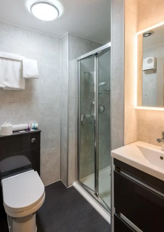 a bathroom with a shower and a toilet and a sink at Inch Hotel in Fort Augustus
