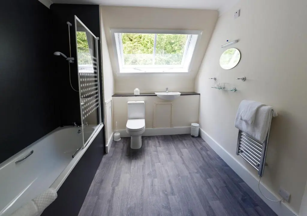 a bathroom with a toilet and a sink and a window at Inch Hotel in Fort Augustus