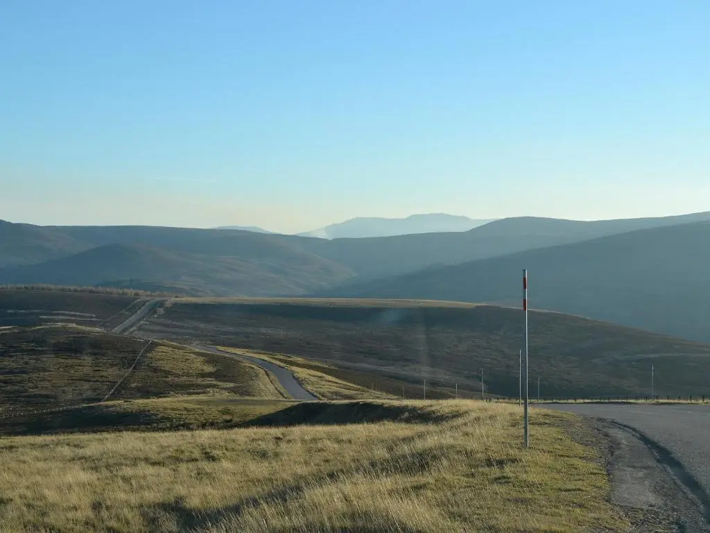 a road in a field next to a body of water at Mountain View in Tomintoul