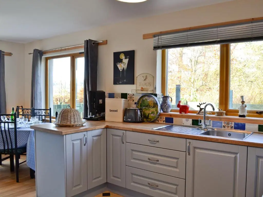 a kitchen with white cabinets and a sink at Mountain View in Tomintoul