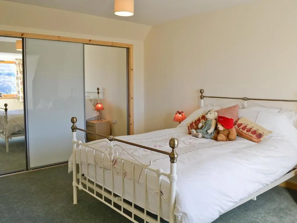a bedroom with a white bed with teddy bears on it at Mountain View in Tomintoul