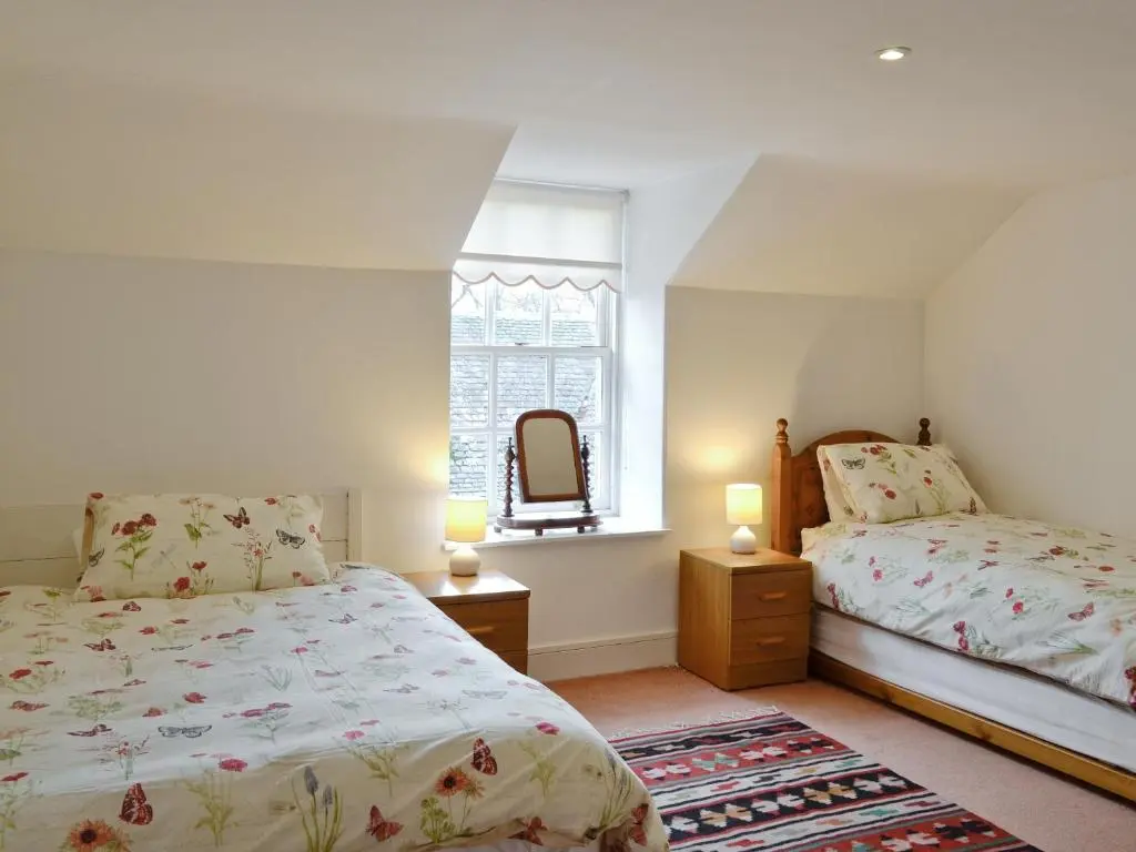 a bedroom with two beds and a window at The Mews in Insch