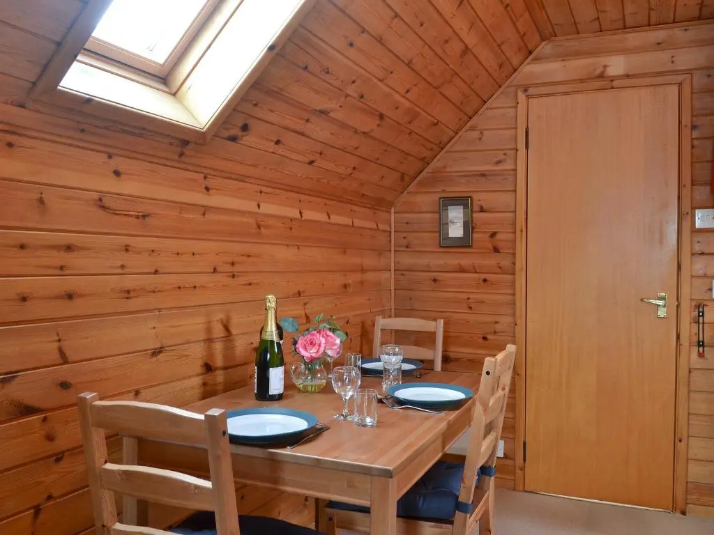 a dining room with a table and a skylight at Wee Ben in Bridge of Tilt