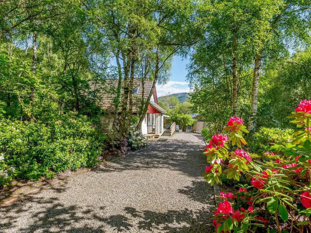 a path leading to a house with flowers and trees at Glen View Of Enrick House in Bearnock