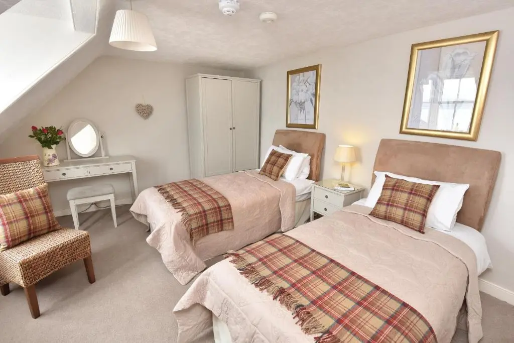 a bedroom with two beds and a desk and a chair at The Royal Hotel Cromarty in Cromarty