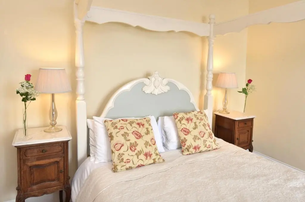 a bedroom with a white bed with two night stands at The Royal Hotel Cromarty in Cromarty