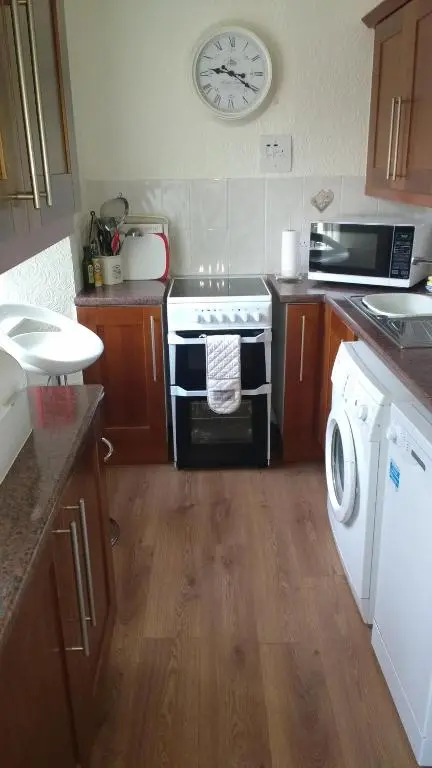 a kitchen with a stove and a washing machine at Inveravon Holiday Home in Dufftown