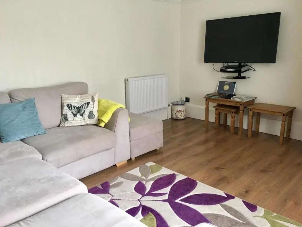 a living room with a couch and a flat screen tv at Inveravon Holiday Home in Dufftown