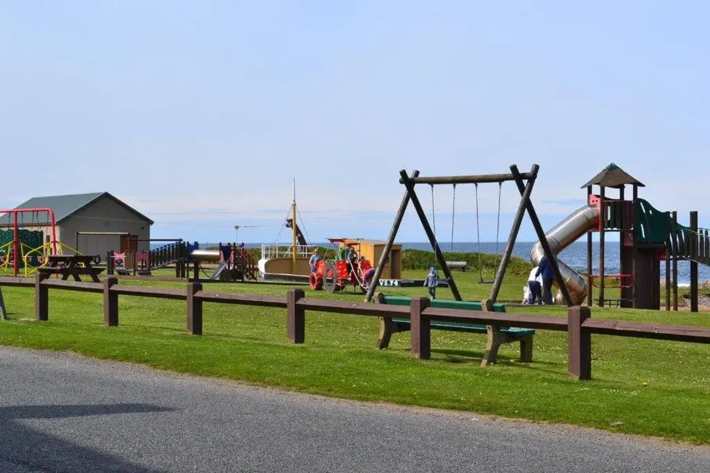 a park with a playground with slides and swings at Belvedere Holiday Home in Whitehills