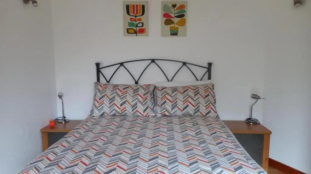 a bedroom with a bed with two night stands and two lamps at North End The Cottage in Nairn