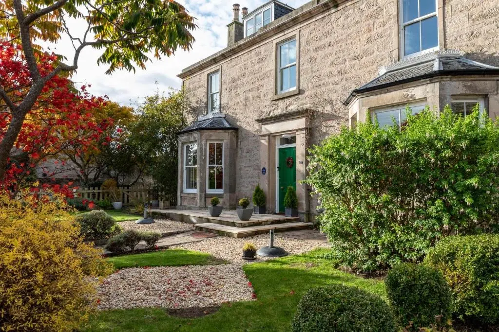 an old brick house with a green door at Cawdor House B&B in Nairn