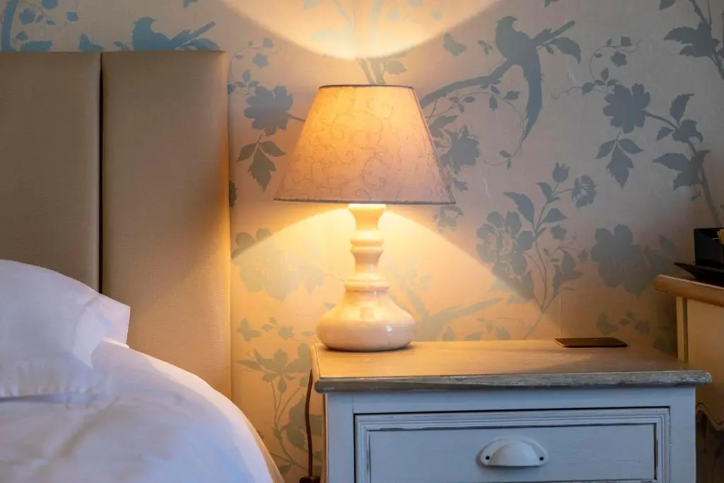 a lamp on a night stand next to a bed at Cawdor House B&B in Nairn