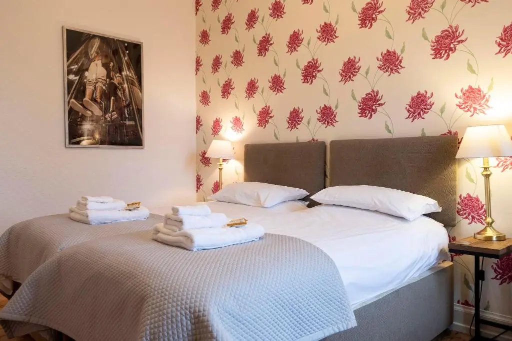 two beds with towels on top of them in a bedroom at Cawdor House B&B in Nairn