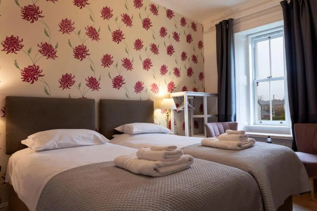 a bedroom with two beds with towels on them at Cawdor House B&B in Nairn