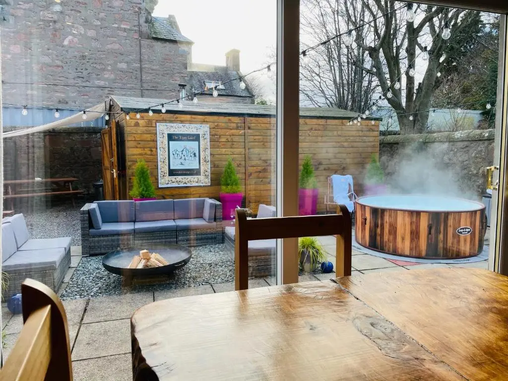 a patio with a table and a fire pit at Lairds Lodge Inverness in Inverness