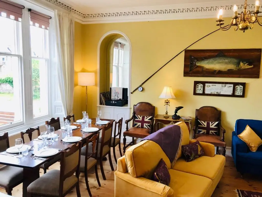 a dining room with a long table and chairs at Lairds Lodge Inverness in Inverness