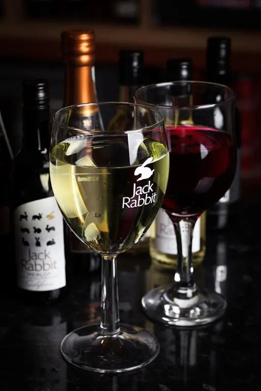 two glasses of wine on a table with bottles of wine at Bannockburn Inn in Helmsdale