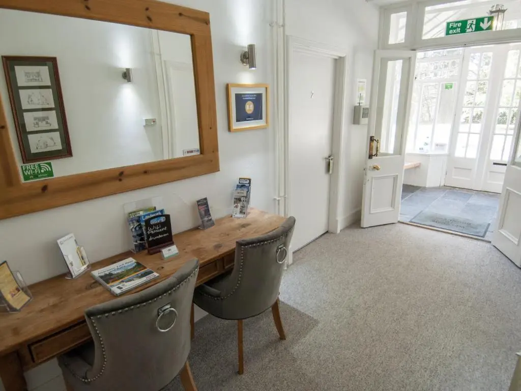 a room with a wooden table with chairs and a mirror at Drumdevan Country House in Inverness