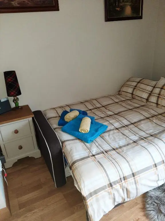 a bedroom with two twin beds and a night stand at Cosy Ness Escape, 16B Ardconnel Street in Inverness