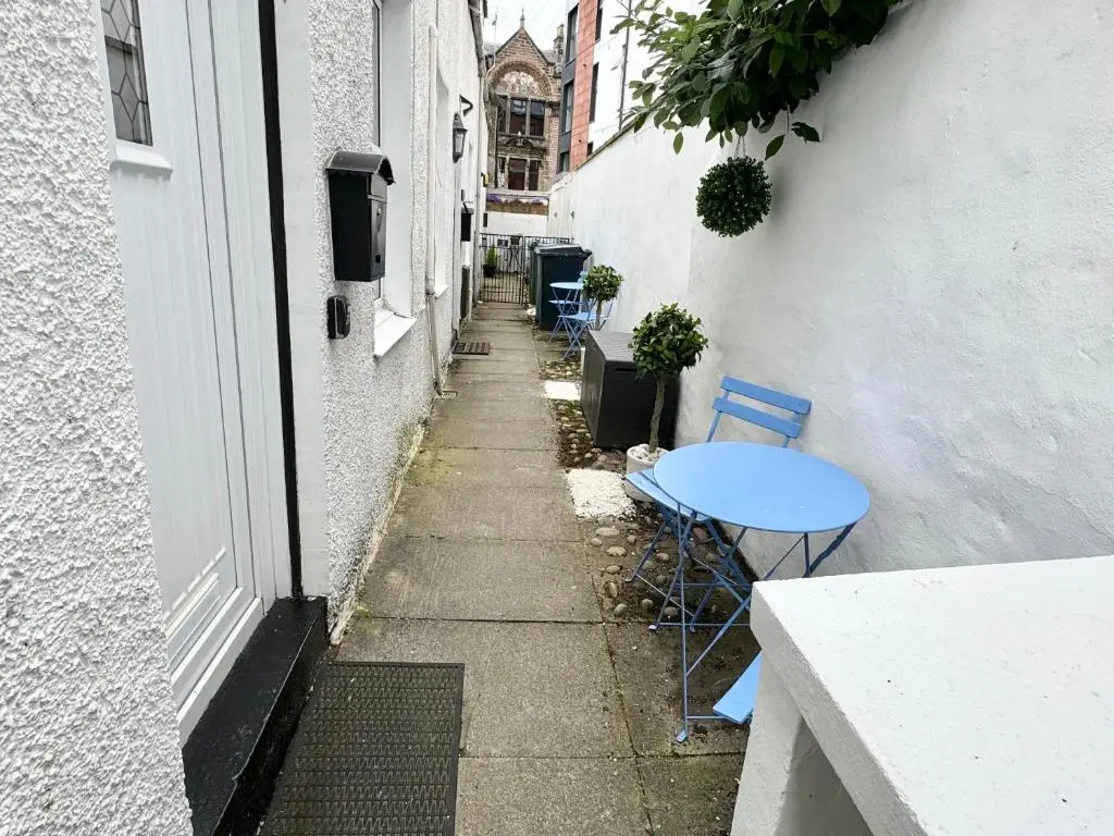 a small alley with a blue table and chairs at City Centre Cottage in Inverness