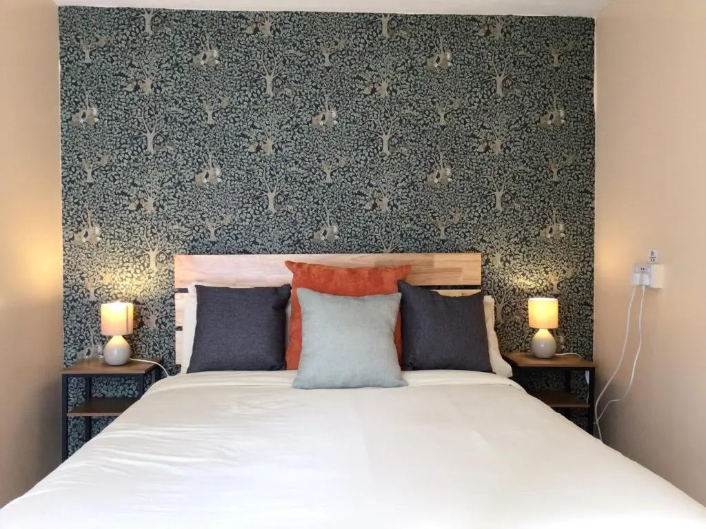 a bedroom with a large bed with two lamps at Loch Ness Backpackers Lodge in Drumnadrochit