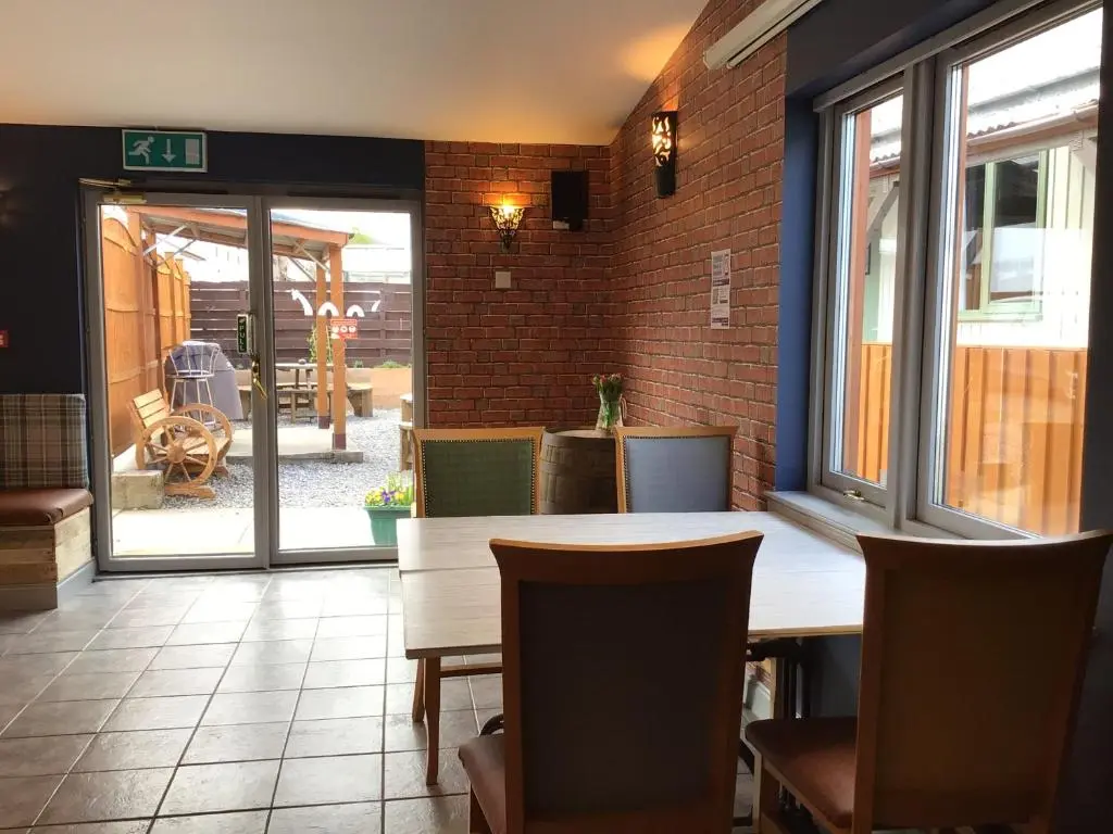 a dining room with a table and chairs and a patio at Loch Ness Backpackers Lodge in Drumnadrochit