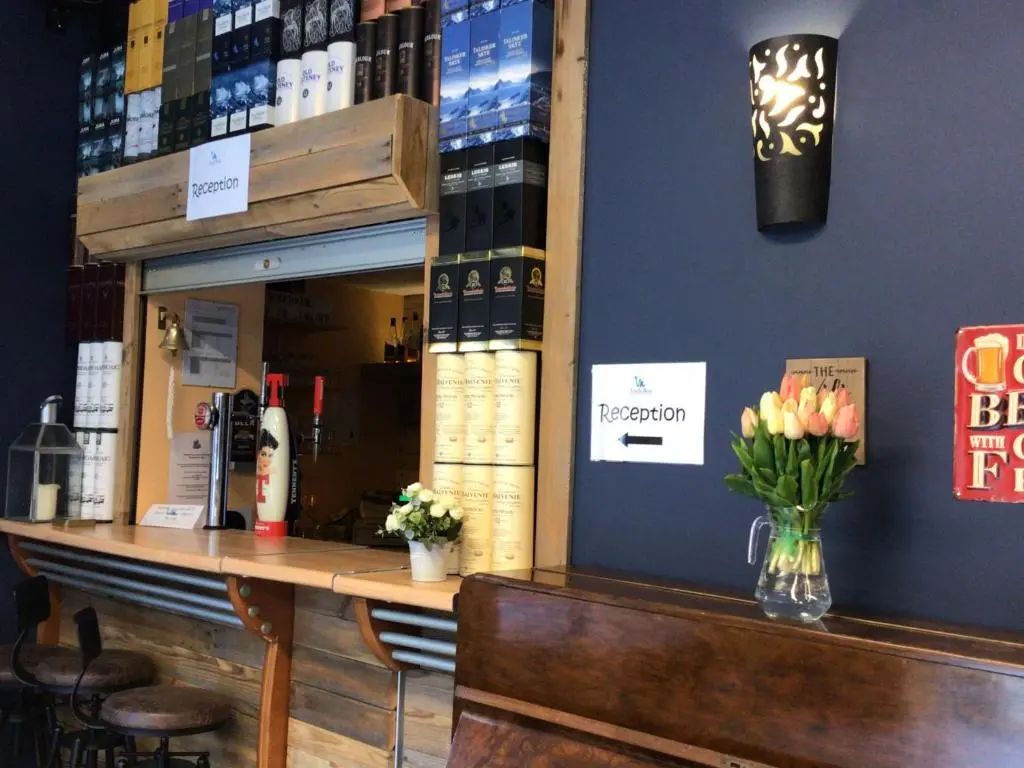 a bar with a vase of flowers on a counter at Loch Ness Backpackers Lodge in Drumnadrochit