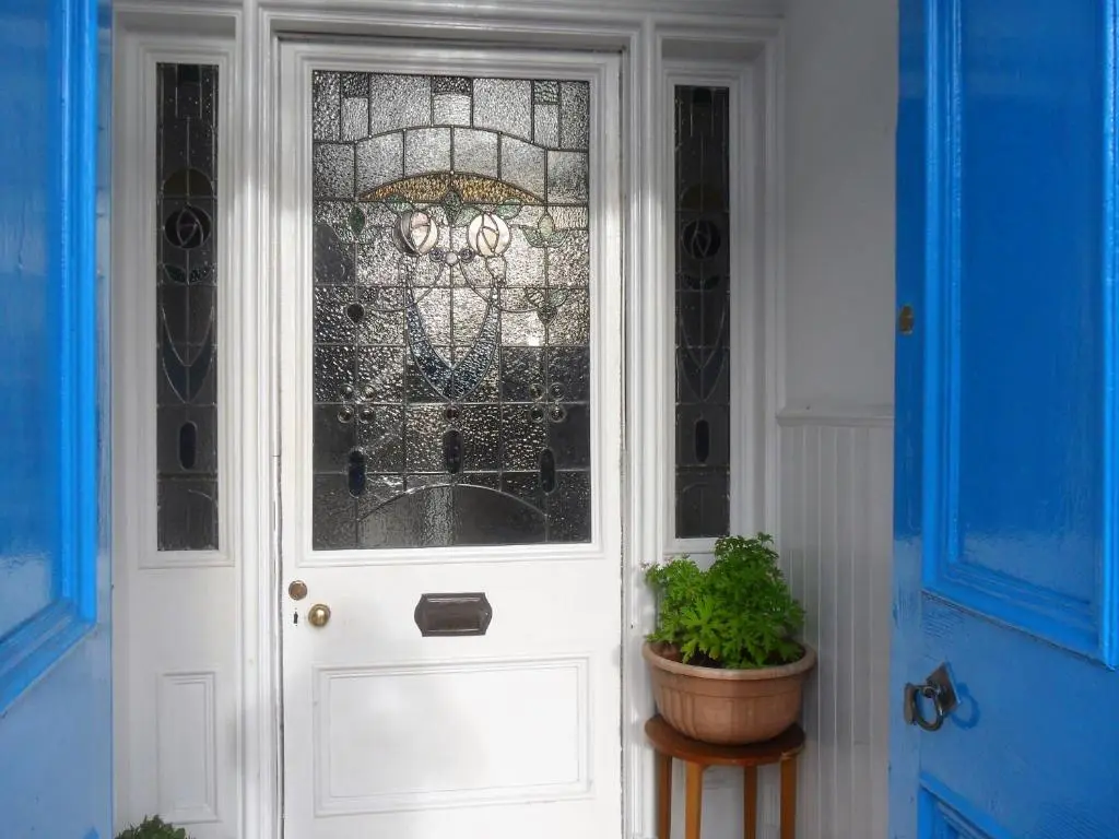 a white door with a glass window and a potted plant at Dunskaith Villa in Inverness