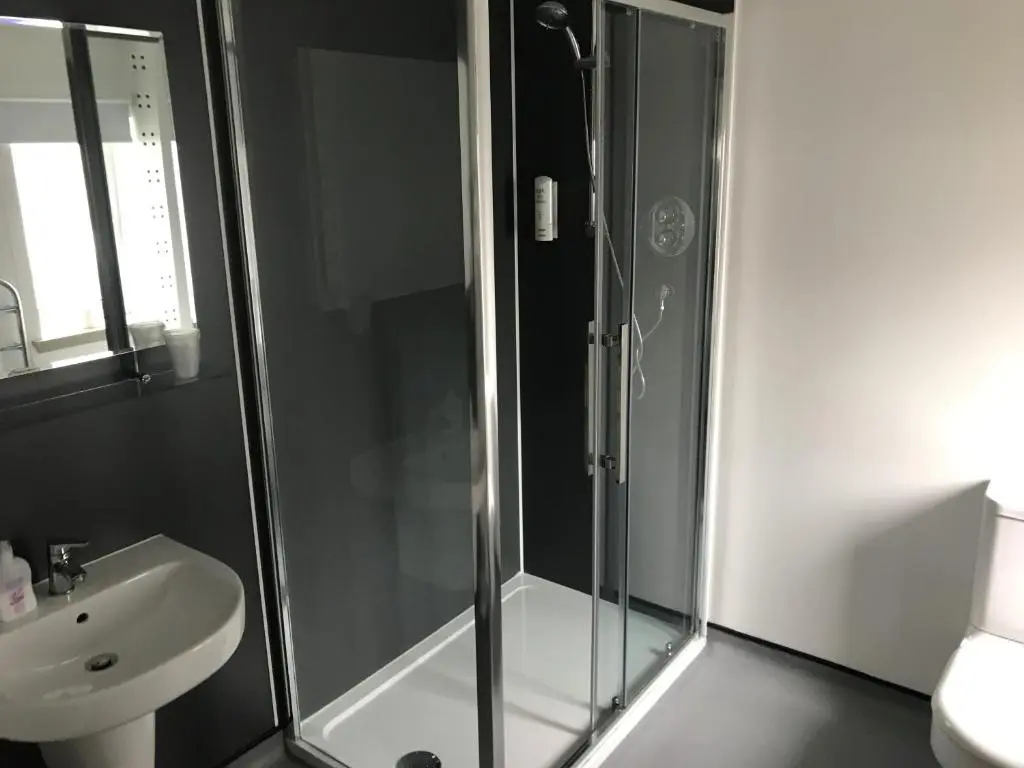 a bathroom with a glass shower and a sink at Buchan Hotel in Ellon