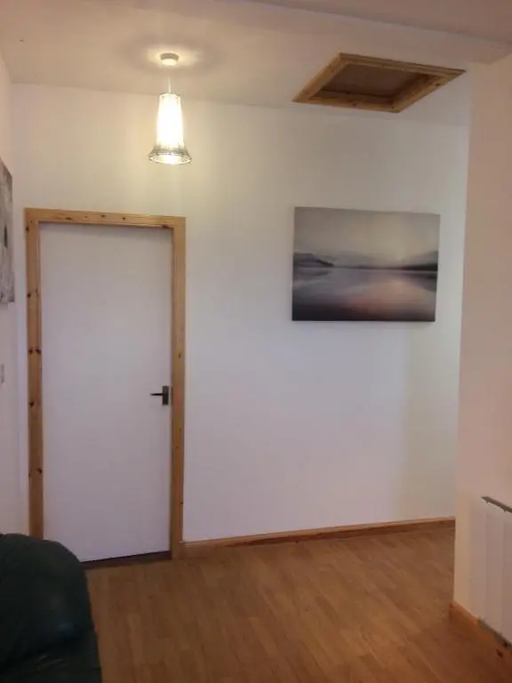 a room with a white door and a painting on the wall at Eastgate Apartment in Inverness