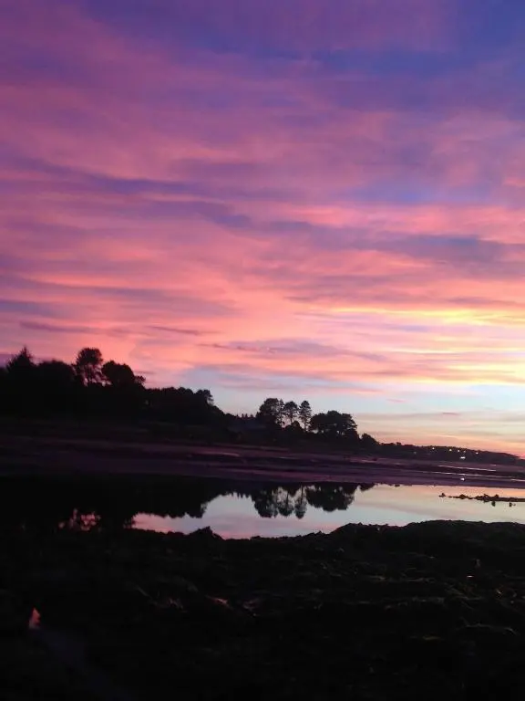 a sunset over a body of water at Luxury Apartment at Barron House in Nairn