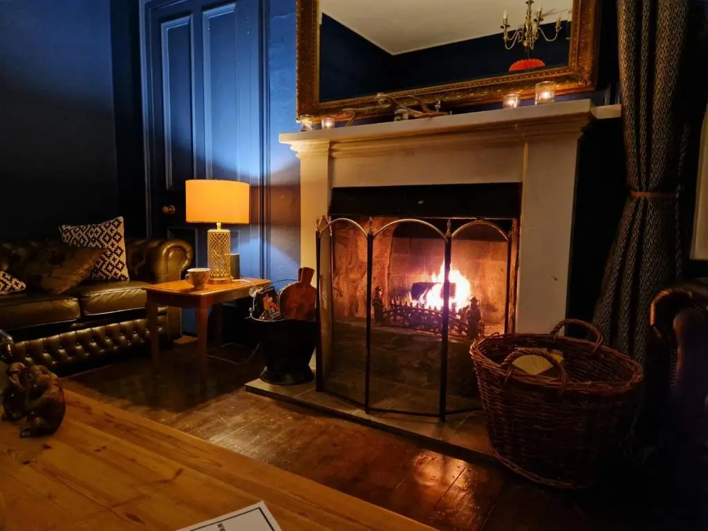 a living room with a fire in a fireplace at Strathardle Lodge in Kirkmichael