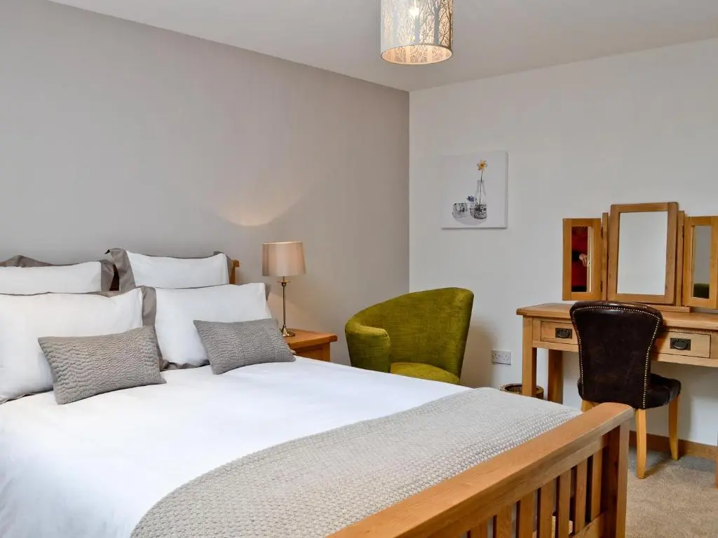 a bedroom with a bed and a desk and chairs at Longcroft Dairy in Oyne