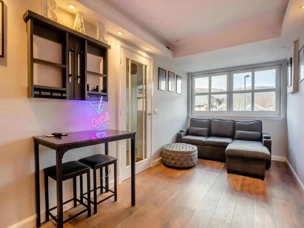 a living room with a table and a couch at Cairnie View in Aviemore