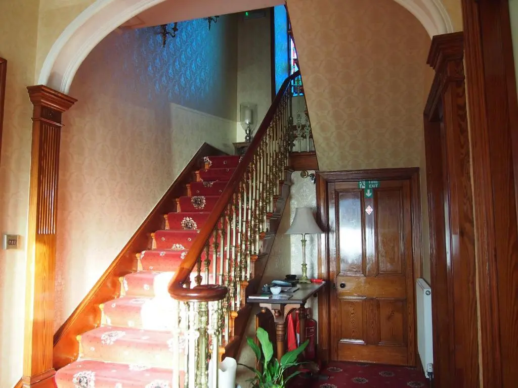 a staircase in a home with a red stair case at Craignay Guest House in Inverness