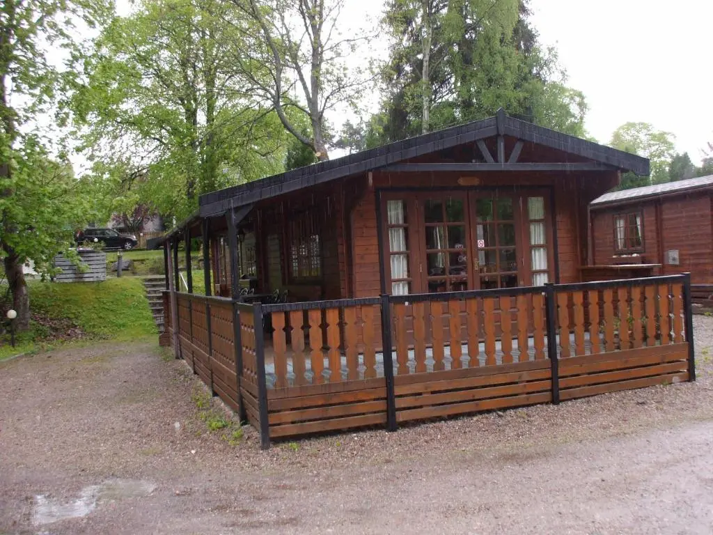 a small building with a fence in front of it at Lurchers Cabin Aviemore in Aviemore