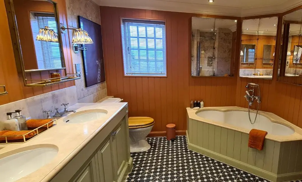 a bathroom with two sinks and a tub and a toilet at The Glenmorangie House in Tain