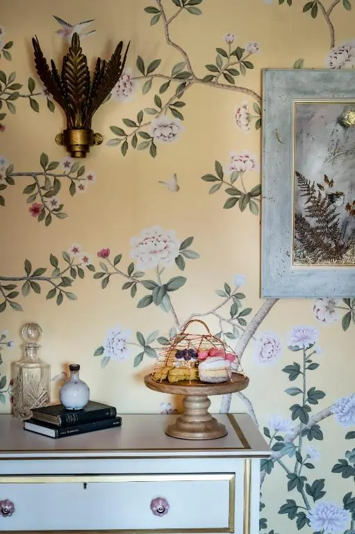 a room with floral wallpaper on the wall with a table at The Glenmorangie House in Tain