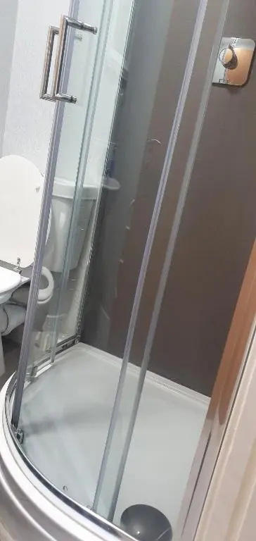 a glass shower door in a bathroom with a toilet at LANGLEY APARTMENT free parking outside between 6 pm and 8 am Secure parking 2 min walk Ideal for TRADES AND TOURISTS WANTING GREAT LOCATION in Inverness