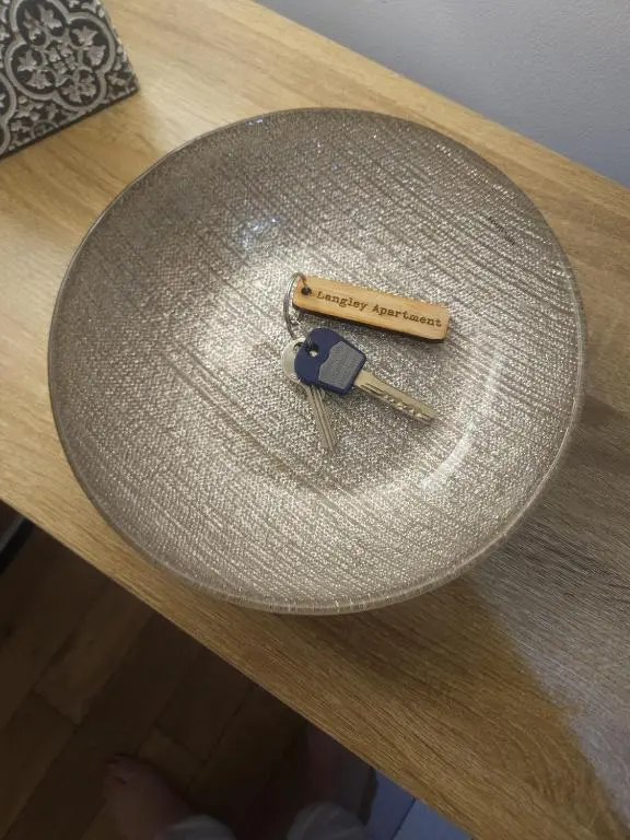 a pair of keys sitting on top of a table at LANGLEY APARTMENT free parking outside between 6 pm and 8 am Secure parking 2 min walk Ideal for TRADES AND TOURISTS WANTING GREAT LOCATION in Inverness