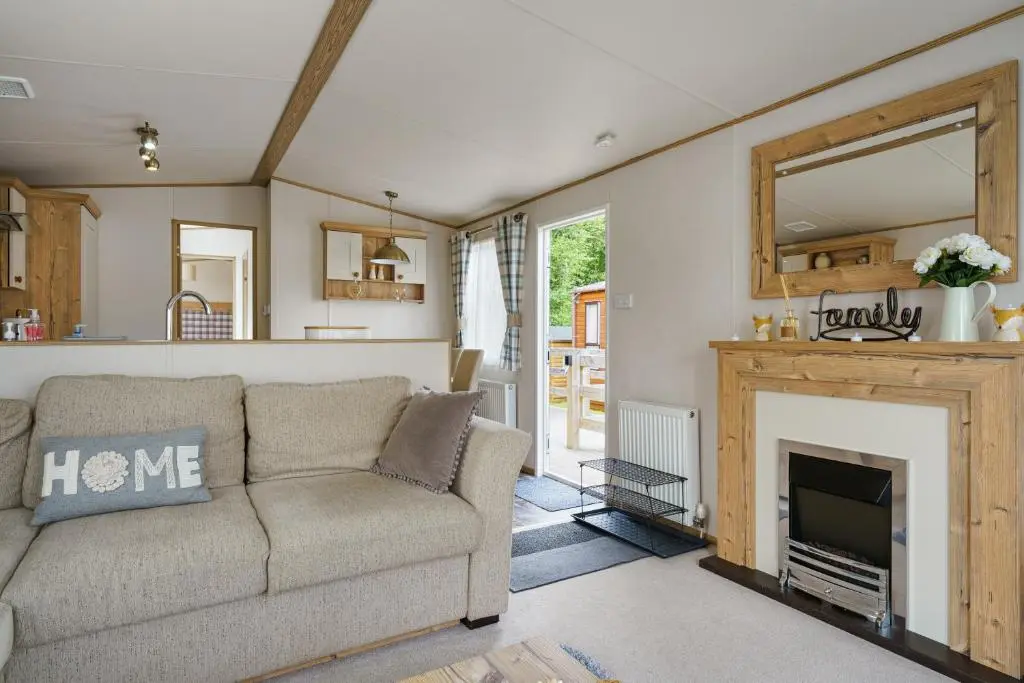 a living room with a couch and a fireplace at Dunroamin Lodge in Aviemore