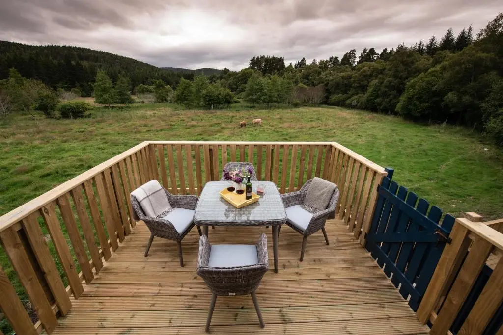 a wooden deck with a table and chairs on it at Tanar View in Aboyne