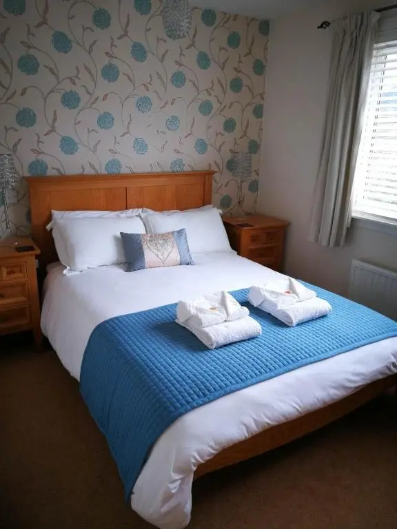 a bedroom with a bed with two towels on it at St Ann\u2019s Guest House in Inverness