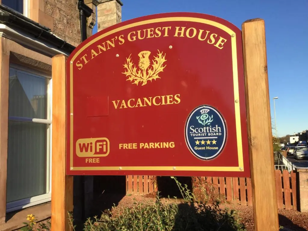 a sign for afw guest house in front of a building at St Ann\u2019s Guest House in Inverness